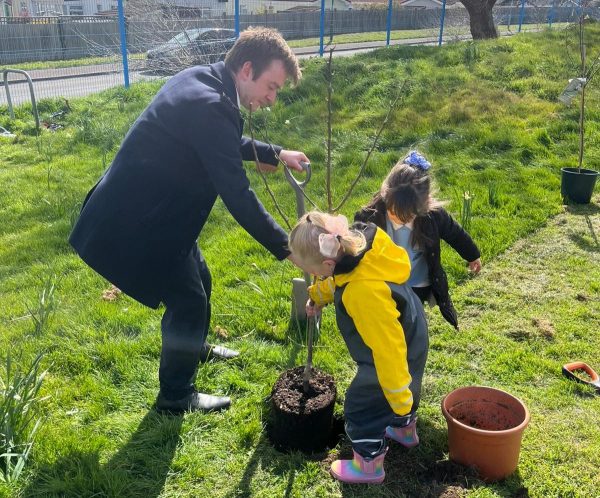 MP Tom Rutland planting a tree with pupils from Seaside Primary School